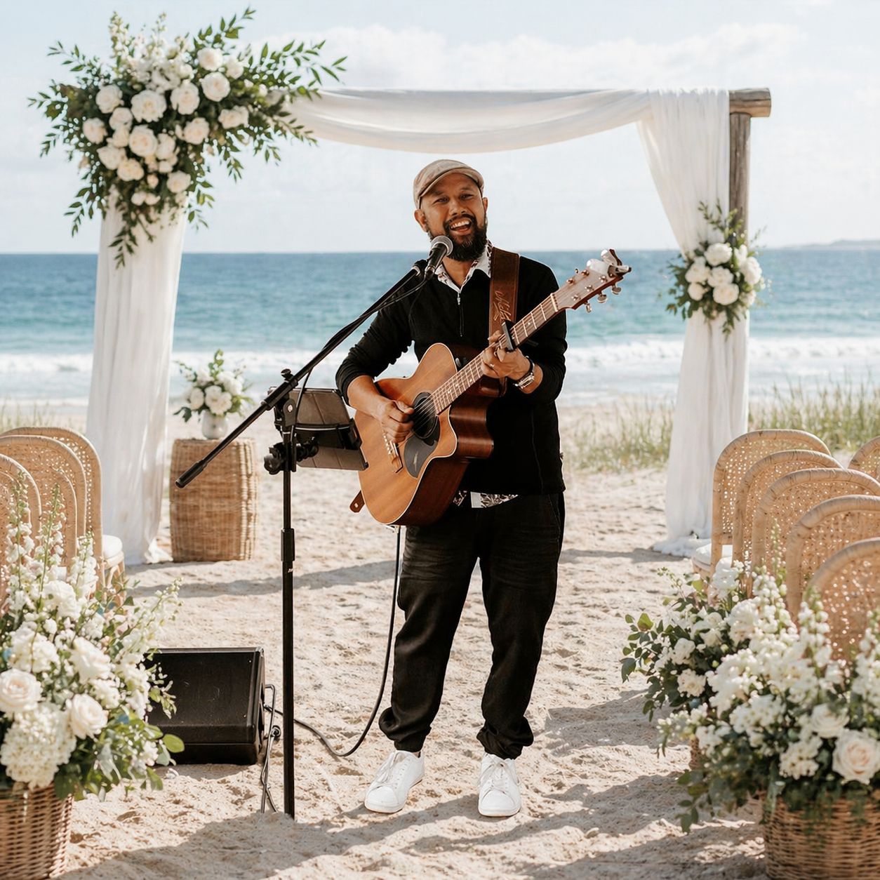 John Veloso singing with an acoustic guitar at a beach wedding ceremony